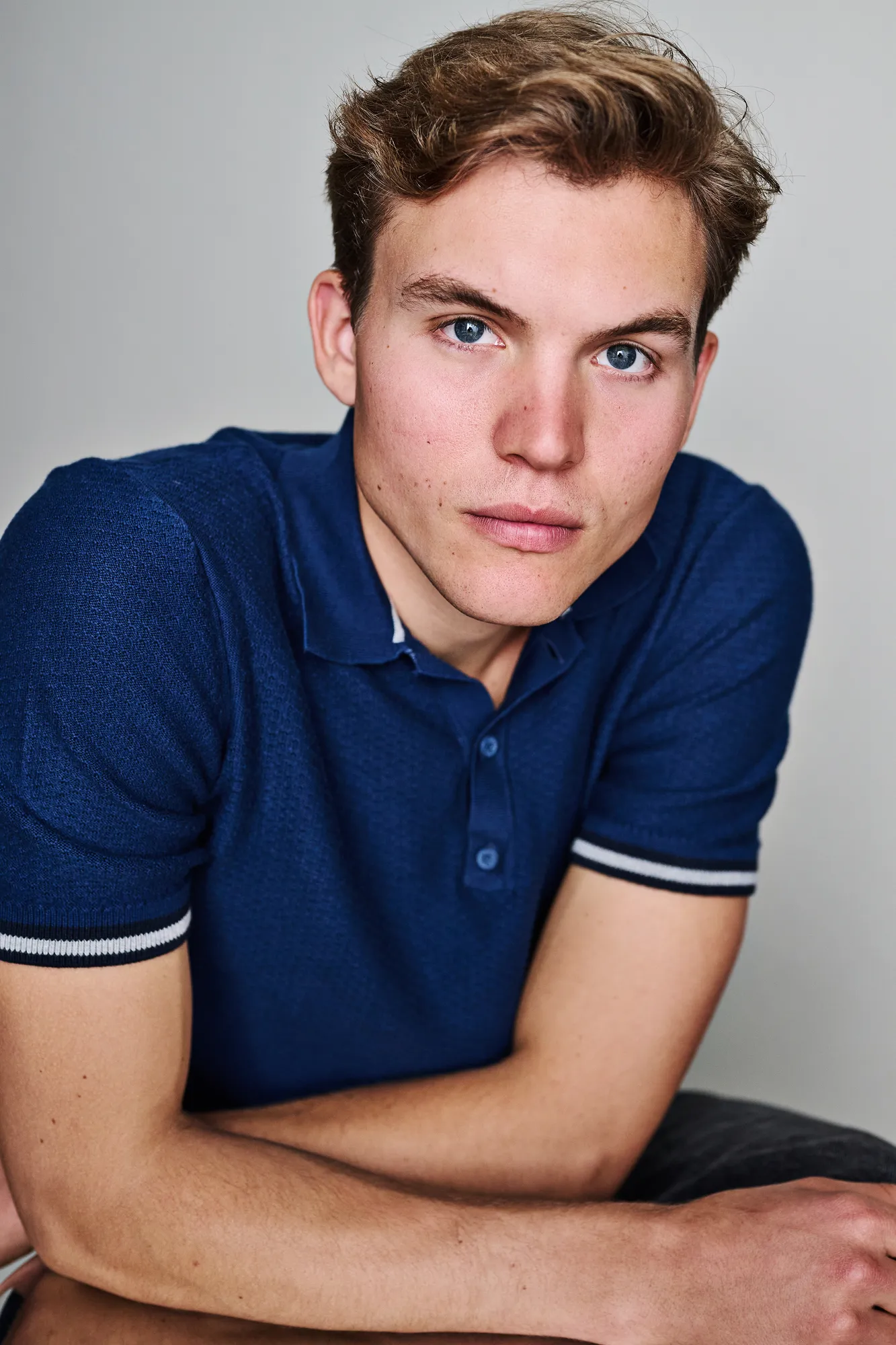 Ferdinand McKay actor headshot in blue polo studio portrait