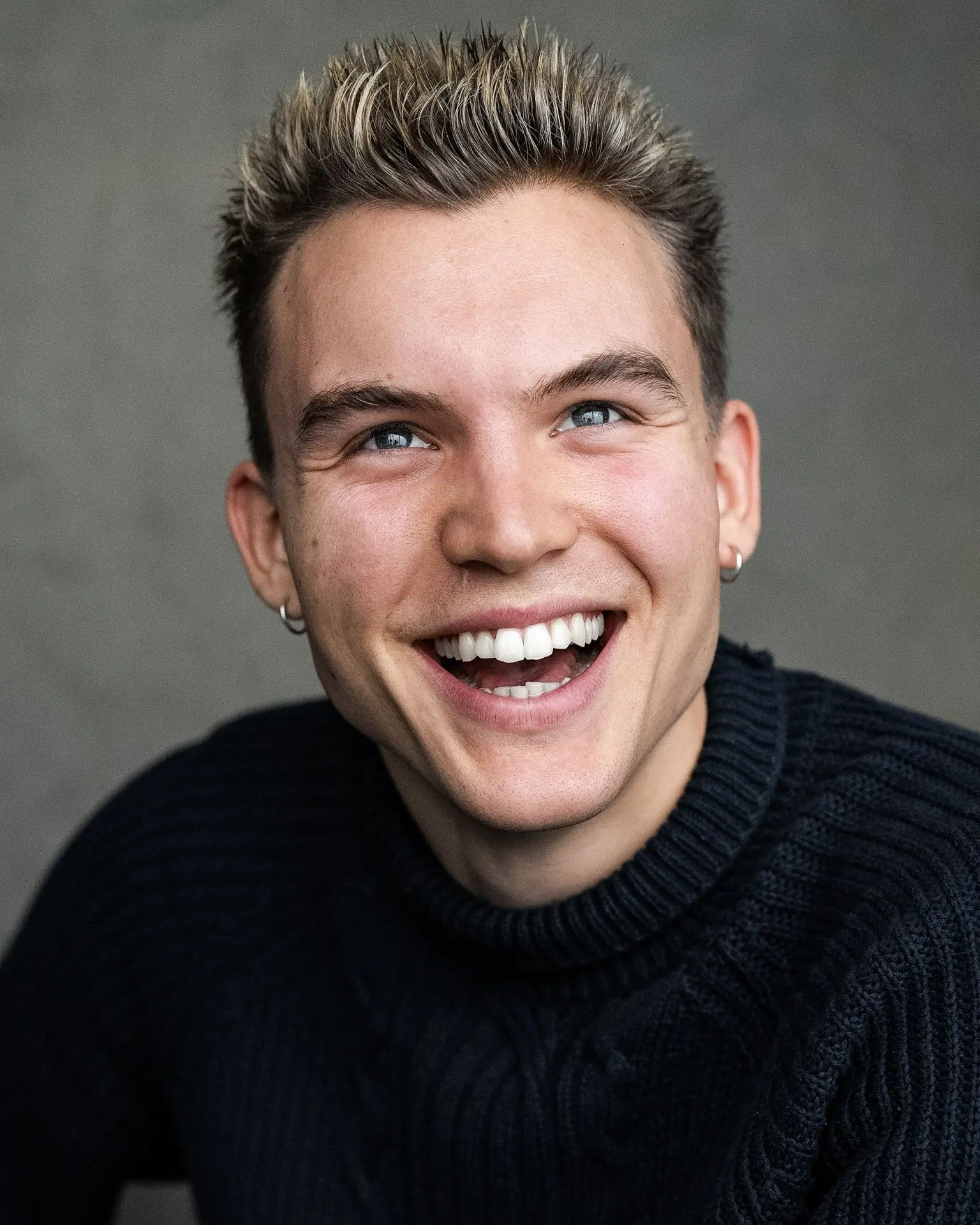 Ferdinand McKay laughing actor headshot in dark sweater