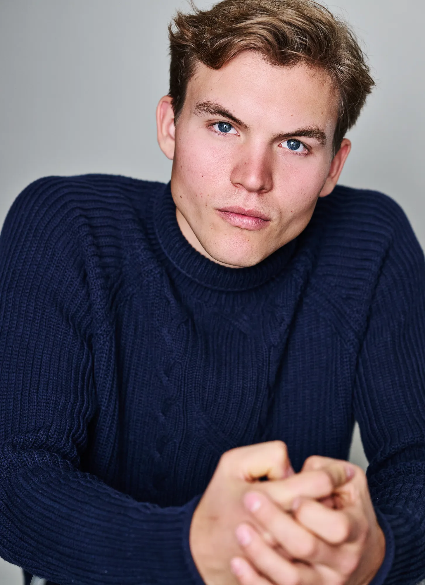 Ferdinand McKay actor headshot in navy cable-knit sweater