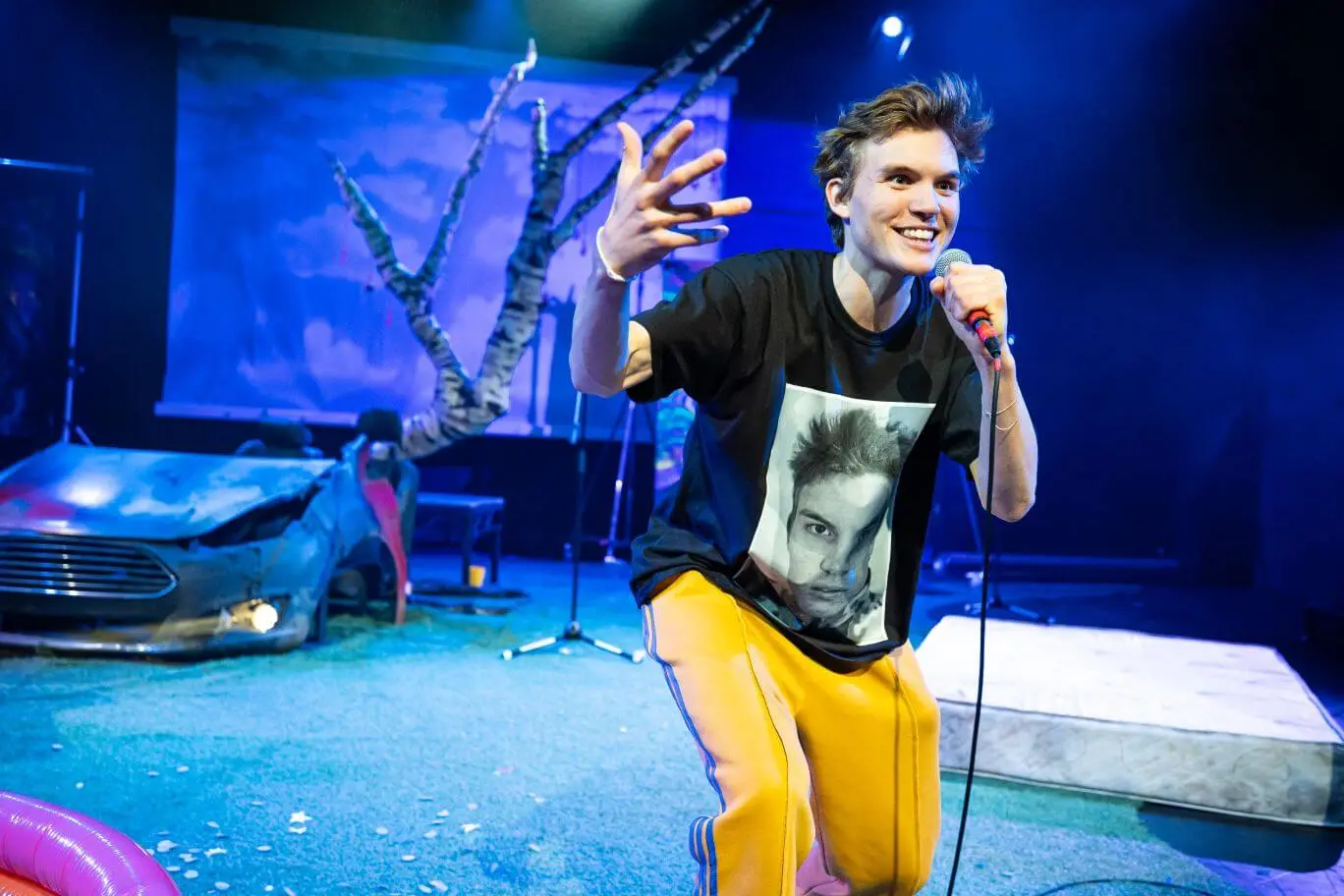 Ferdinand McKay performing with microphone on blue-lit stage