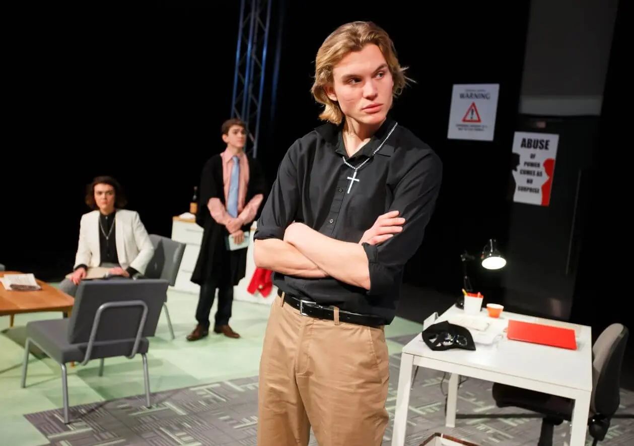 Ferdinand McKay on stage in black shirt theatre performance